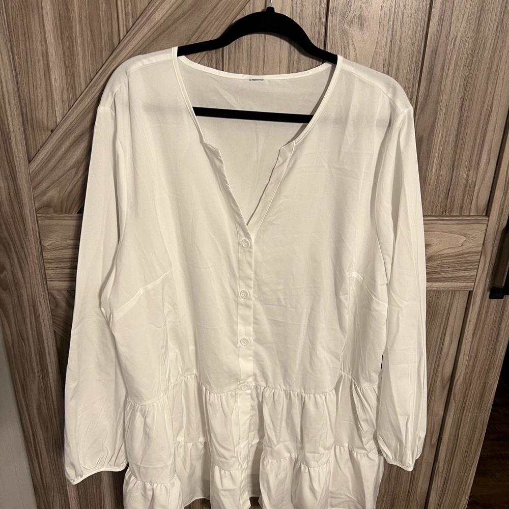 New without tags white tunic with ruffles around bottom hem.
